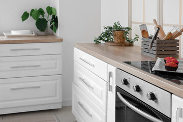 Electric oven and tray with fresh muffins in interior of modern kitchen