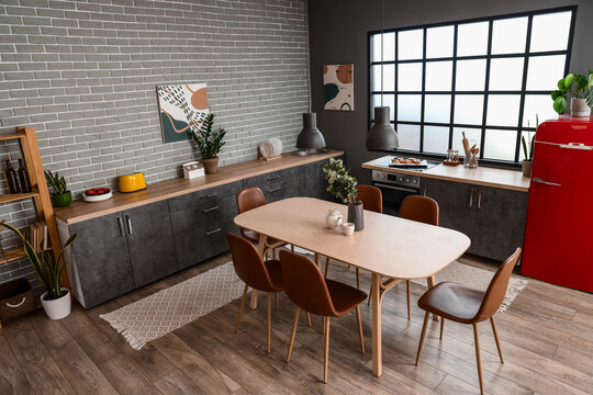 Interior of modern kitchen with dining table and grey counters