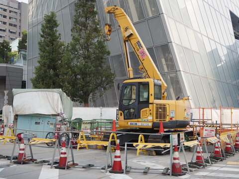 TOKYO, JAPAN - 25th June, 2023: View of a crane on a street by an underconstruction building which is part of the Toranomon Hills Station Tower development in central Tokyo.
