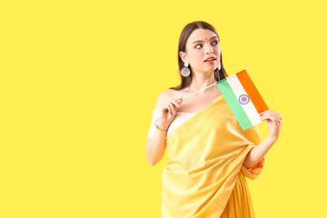 Young woman with Indian flag on yellow background