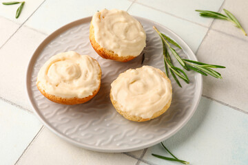 Plate of tasty croutons with cream cheese on white tile background