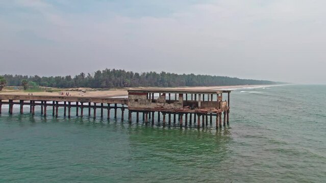 abandoned walking bridge in to the sea lay to ruins drone shot addaripeta beach 4k