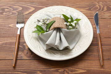 Beautiful table setting with gypsophila flowers and plant leaves on wooden table