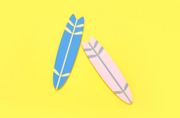 Mini colorful surfboards on yellow background
