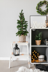 Stepladder with Christmas tree, lantern and glowing lights in room