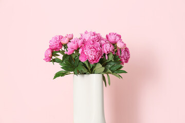 Fototapeta premium Vase of pink peonies on color background