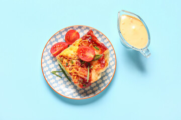 Plate of pasta with tomato sauce and cheese on blue background