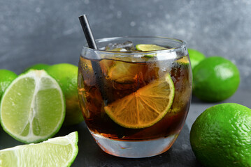 Glass of cold Cuba Libre cocktail on grey background