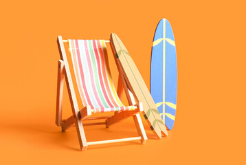 Composition with mini surfboards and deckchair on orange background