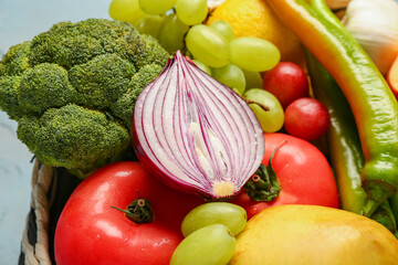 Wicker bowl with different fresh fruits and vegetables, closeup