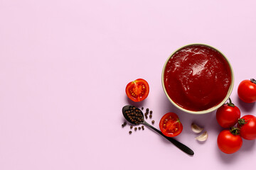 Bowl with tomato paste and fresh vegetables on lilac background