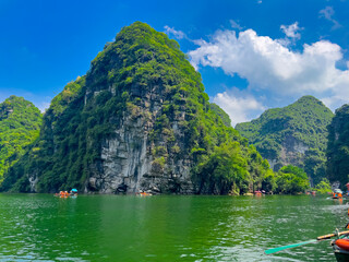 Trang An River Ninh Minh and Bai Dinh Mountain ranges in Vietnam only 3 hours drive from Hanoi. Beautiful winding river and large rising mountains. boats going through the caves in the river - Powered by Adobe