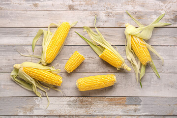 Fresh corn cobs on grey wooden background