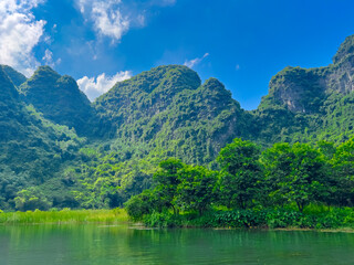 Trang An River Ninh Minh and Bai Dinh Mountain ranges in Vietnam only 3 hours drive from Hanoi. Beautiful winding river and large rising mountains. boats going through the caves in the river