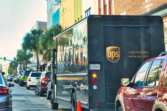 charleston, united states - november 7 2022: old historic building with shops and stores and ups delivery truck parked on small street in downtown