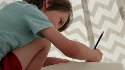 Young boy erasing drawing in outdoor fort - close up