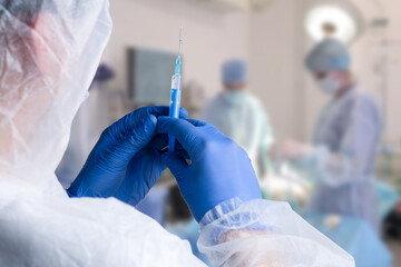 close up of male doctor holding syringe with injection.