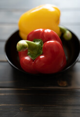 gelbe und rote Paprika in einer schwarzen Schale