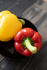 gelbe und rote Paprika in einer schwarzen Schale