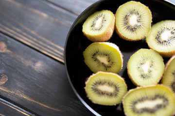Kiwi, halbiert in einer schwarzen Schale