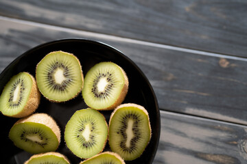 Kiwi, halbiert in einer schwarzen Schale