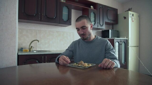 The Man Tastes the Food and, with Disgust, Pushes the Plate of Food aside. Man Having No Appetite, Eating Disorder, Depression Problem. No Appetite. This is Disgusting.