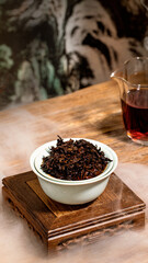 Chinese black tea in a glass cup, traditional tea set, oriental style interior scene, fog formed by dry ice on the table