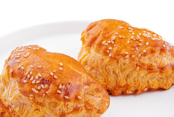 Puff pastry with sesame seeds on white plate