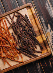 Beef and chiken jerky on wooden board