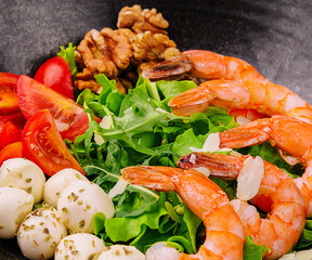 Salad with fresh arugula leaves, mozzarella cheese and shrimps