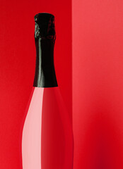 Red bottle of champagne on yellow background