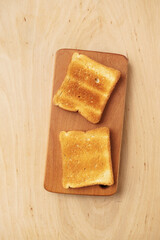 Two appetizing toasts on a wooden board, top view