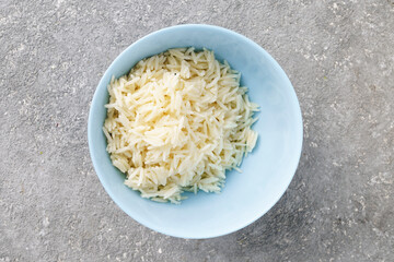 Boiled long rice in a bowl on a concrete background, top view