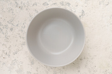 Empty gray bowl on light concrete background, top view