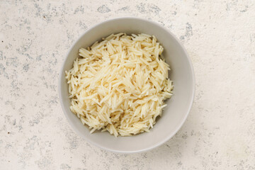 Boiled long rice in a bowl on a concrete background, top view