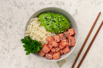 Poke bowl with salmon, rice, avocado, cucumber, radish, pepper, sesame seeds