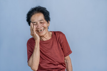 Asian elderly woman with severe toothache holding her cheek to relieve pain Unhappy senior woman...