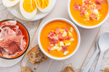 Salmorejo - raw tomato soup with ingredients on a kitchen table,  spanish cuisine for hot summer