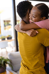 Happy african american couple embracing in living room