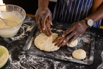 Fotobehang Hands of african american couple in aprons preparing bread dough in kitchen © WavebreakMediaMicro