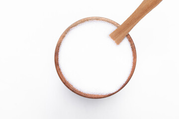 Sól spożywcza w drewnianej okrągłej miseczce z łyżeczką na białym tle