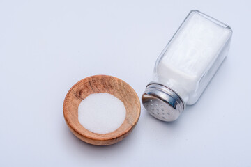 Solniczka i sól w drewnianej okrągłej miseczce na białym tle - obrazy, fototapety, plakaty