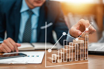 Plan and strategy in business. Business development and growth concepts. Businessman hand pulling downs or placing wood block on the tower and semi-pyramid in modern office.