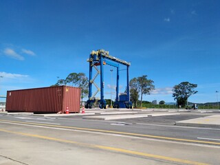 Cranes lift containers in a shipping port.