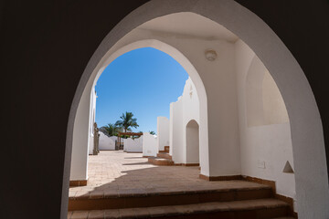 White wall buildings with the arch on the street on sunny day in resort town Sharm El Sheikh, Egypt,