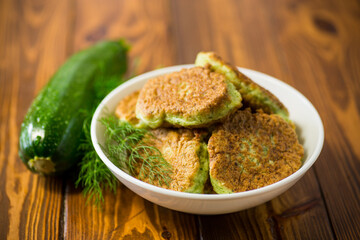 fried zucchini pancakes with herbs, in a plate .