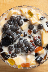 top view bowl of grass jelly on a wood background at vertical composition