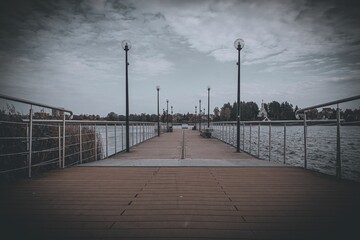 Wooden pier with benches on a lake on a cloudy day