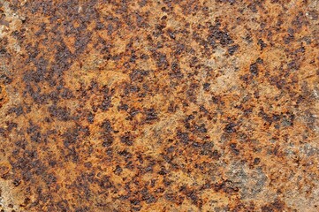 a piece of rusted metal showing brown and black areas