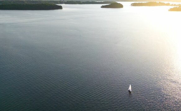 Aerial view of a sailboat drifting across the serene waters of Lake Norman in Cornelius, NC